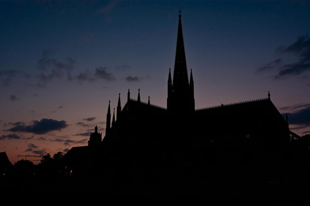 A building is a solid, static thing, a monument of concrete, steel, and glass. We see it as a permanent fixture in the urban landscape. But every day, it creates something fluid and alive: its own shadow. This photographic essay, "The Weight of Shadow," is a study of how these moving patterns of darkness become unintentional memorials. It explores the way a building’s shadow travels across neighboring walls and streets, marking the passage of time and subtly shaping the emotional geography of the city. It is an attempt to photograph not the structure itself, but its silent, temporal twin.
The Slow Sweep of a Sundial
To watch a building's shadow over the course of a day is to witness the city as a giant sundial. The sharp edge of a skyscraper’s shadow begins at dawn, long and distorted, stretching across streets and sleeping facades. As the sun climbs, the shadow contracts, becoming a dark, cool pool at the building's base. By late afternoon, it lengthens again, reaching in the opposite direction, its form softening as the light fades. Photographing this slow, deliberate sweep is an exercise in patience. It requires returning to the same spot, hour after hour, to capture the silent, inexorable march of time painted in shades of grey.
A Seasonal Pilgrimage
The path of a shadow is not just a daily journey, but a seasonal one. In winter, when the sun hangs low in the sky, a building casts a long, persistent shadow that can keep a neighboring courtyard in a state of perpetual twilight. In summer, the sun is high and the shadow’s reach is shorter, offering a brief, sharp respite from the heat. This seasonal pilgrimage changes the character of the spaces it touches. A wall that is sun-drenched in June might be cloaked in shadow all day in December. Tracking this annual change reveals the building's enduring, cyclical impact on its environment, a concept of time and place beautifully captured in the land art movement, documented by organizations like the Holt/Smithson Foundation.
