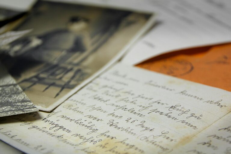 This close-up composition features a collection of vintage memorabilia, highlighting a handwritten letter with elegant cursive script alongside a blurred black-and-white photograph.