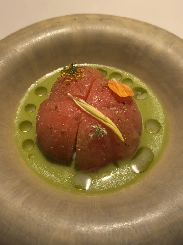 Gourmet heirloom tomato dish with green gazpacho and edible flowers at Belimbing restaurant.