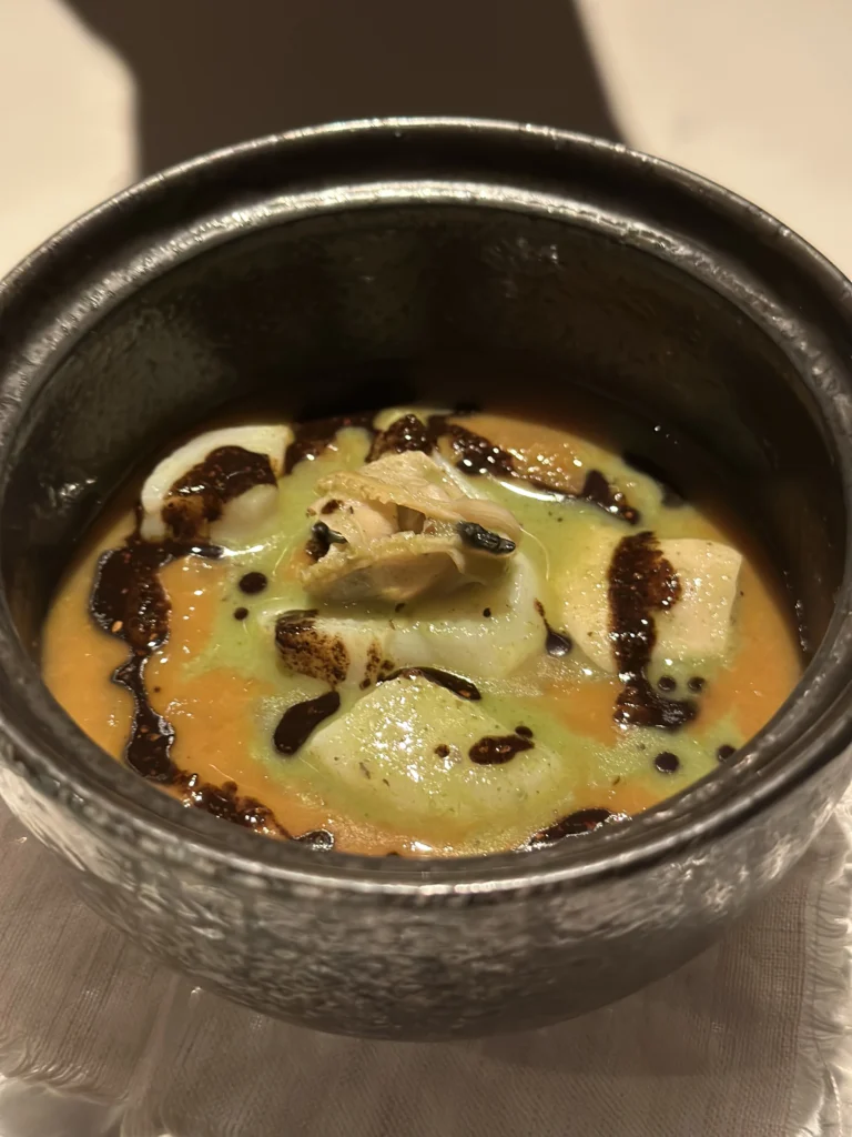 Gourmet seafood soup with clams and herb oil drizzle at Belimbing restaurant.
