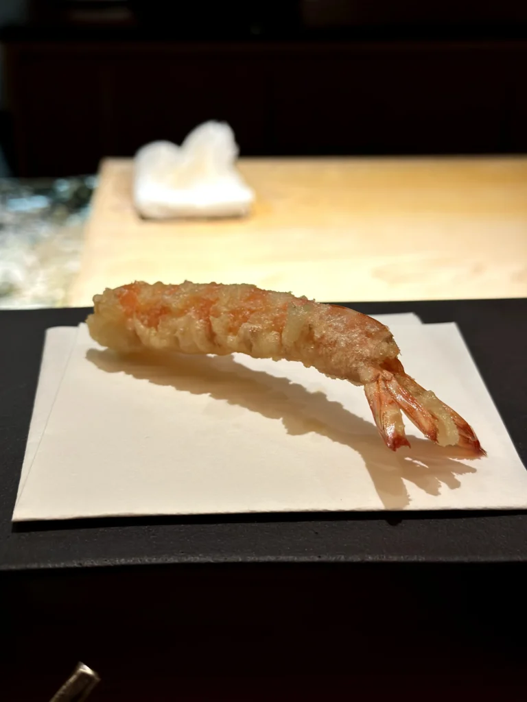 Tiger prawn tempura with a light golden batter, served fresh at a traditional Japanese omakase restaurant.