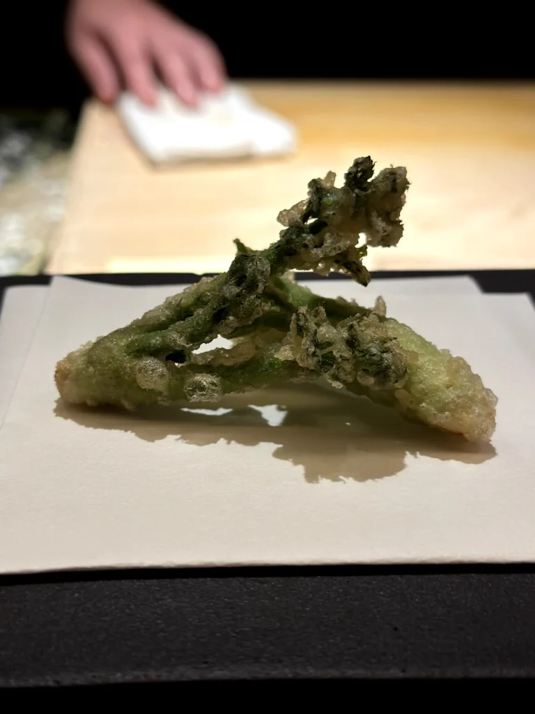 Seasonal vegetable tempura with a light crispy batter, served as part of a premium Japanese omakase course.